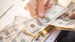 hands counting out 100 dollar bills | cash flow