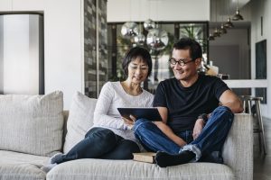 husband and wife reviewing smart money moves on the couch